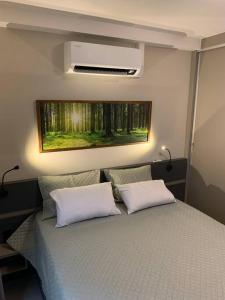 um quarto com uma cama com duas almofadas brancas em O Lugar! Apto no The Place em São José dos Campos