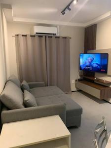 a living room with a couch and a flat screen tv at O Lugar! Apto no The Place in São José dos Campos