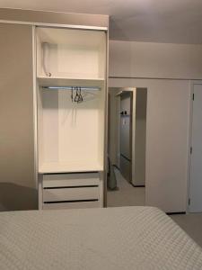um quarto com armários brancos e uma cama nele em O Lugar! Apto no The Place em São José dos Campos