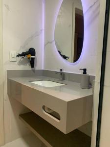 a bathroom with a sink and a mirror at O Lugar! Apto no The Place in São José dos Campos