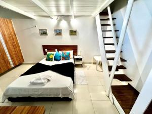 a bedroom with two beds and a spiral staircase at Mini paraíso do Francês/ Pé na areia in Marechal Deodoro