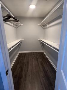 a walk in closet with wood floors and shelves at The Central Crib in Kansas City