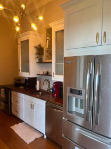a kitchen with stainless steel appliances and white cabinets at Masseys on Grove Unit B in Vicksburg