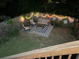 een patio met 2 stoelen en een tafel voor een hek bij Masseys on Grove Unit B in Vicksburg