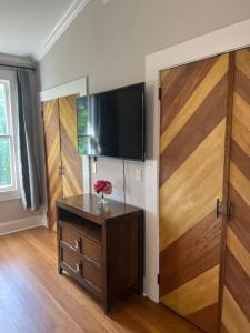 een kamer met een televisie aan een muur met een houten deur bij Masseys on Grove Unit B in Vicksburg