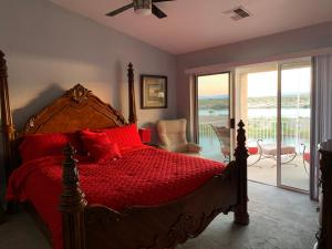um quarto com uma cama com almofadas vermelhas e uma varanda em RIVERFRONT RUBY RED HOME WITH PRIVATE DOCK em Bullhead City