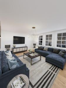 a living room with two blue couches and a tv at Mayfair Pied de Tier sleeps 6ppl in London