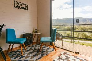 2 sillas en una habitación con vistas a las montañas en CHALE SOL NASCENTE en Urubici