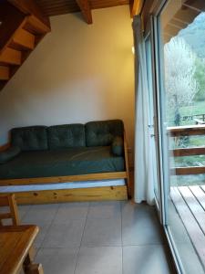 un sofá en la esquina de una habitación con ventana en Pirque mínimo 4 noches en San Carlos de Bariloche