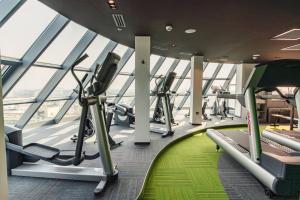 a gym with treadmills and ellipticals in a building at Holiday Inn Bucharest - Times by IHG in Bucharest