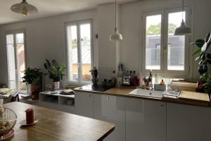 a kitchen with a sink and a counter with windows at Spacious 70 m renovated duplex family home in Suresnes