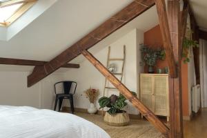 een slaapkamer op zolder met een bed en een stoel bij Spacious 70 m renovated duplex family home in Suresnes