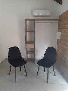 two black chairs sitting in a room with a closet at Zabriko delair in Sainte-Anne