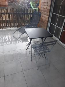 a black table and a chair on a patio at Zabriko delair in Sainte-Anne