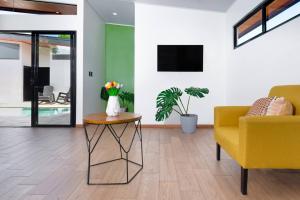ein Wohnzimmer mit einem gelben Sofa und einem Tisch in der Unterkunft Casa Coral - great location - high speed internet in Uvita