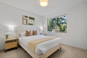 a white bedroom with a large bed and a window at New Meridian Park Shoreline WA in Shoreline