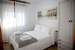 a bedroom with a white bed with two towels on it at Casa Rural Fidalgo in Chantada