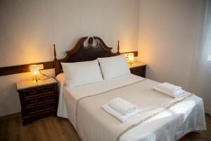 a bedroom with a bed with two towels on it at Casa Rural Fidalgo in Chantada +66 photos