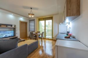 a kitchen and living room with a couch and a table at Apartmani Oktobar 06 in Zlatibor