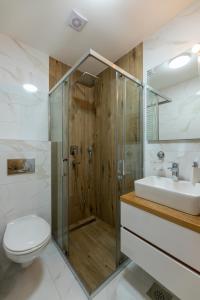 een badkamer met een douche, een toilet en een wastafel bij Apartmani Oktobar 06 in Zlatibor