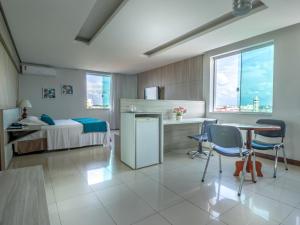 a bedroom with a bed and a table and chairs at Posseidon Hotel in Imperatriz