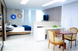 1 dormitorio con 1 cama, mesa y sillas en Posseidon Hotel, en Imperatriz