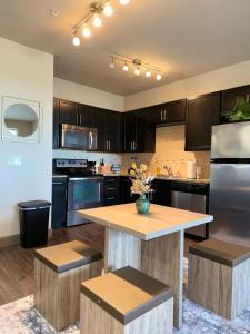 Luxury Apartment in Dallas في أديسون: مطبخ مع دواليب خشبية وطاولة مع كراسي