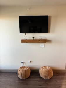 two wooden spheres sitting on the floor in front of a tv at Luxury Apartment in Dallas in Addison