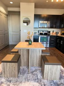 a kitchen with a wooden table and two stools at Luxury Apartment in Dallas in Addison