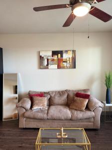 - un salon avec un canapé brun et un ventilateur de plafond dans l'établissement Luxury Apartment in Dallas, à Addison