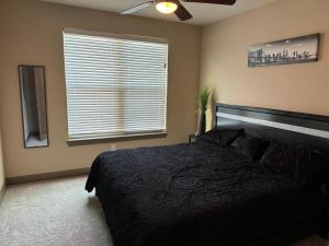 um quarto com uma cama preta e uma janela em Luxury Apartment in Dallas em Addison