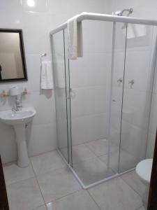 a bathroom with a shower and a sink at Pousada Nó de Pinho in Urubici