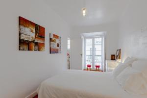 リスボンにあるVisit Lisbon 4fun - Anjos Apartmentの白いベッドルーム(白いベッド1台、窓付)
