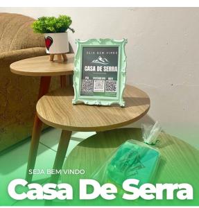 a sign on a table next to a table with a plant at Casa de serra -3 quartos in Ubajara