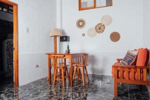 um quarto com uma mesa e cadeiras e um sofá em Hotel Pimampiro em Puerto Baquerizo Moreno