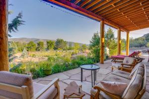 a patio with couches and a table and chairs at Peaceful Historic Cottage on Sedona Wine Trail in Cottonwood