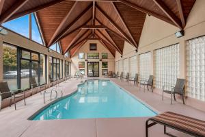 a swimming pool in a building with tables and chairs at Best Western Town and Country Inn in Cedar City