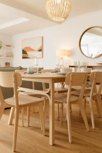 uma sala de jantar com uma mesa de madeira e cadeiras em Vida Central - 2 bed, 1.5 bath w parking, gym & pool em Newcastle