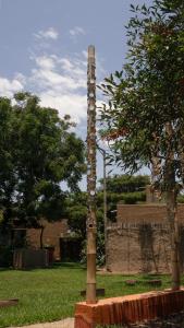a totem pole in the middle of a park at DE SOL Y BARRO Moche Trujillo in Trujillo