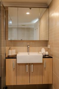 a bathroom with a sink and a mirror at Vida Central - 2 bed, 1.5 bath w parking, gym & pool in Newcastle