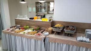 una mesa con un buffet de comida. en SAPA Studios & Apartments, en Niš