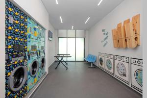 a laundry room with washing machines and a table at Rove La Mer Beach, Jumeirah in Dubai