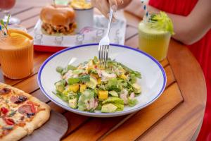 a plate of salad with a fork on a table at Rove La Mer Beach, Jumeirah in Dubai