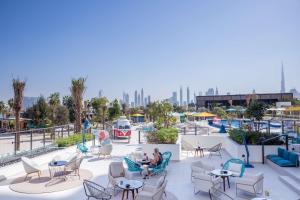 a group of people sitting on the roof of a resort at Rove La Mer Beach, Jumeirah in Dubai