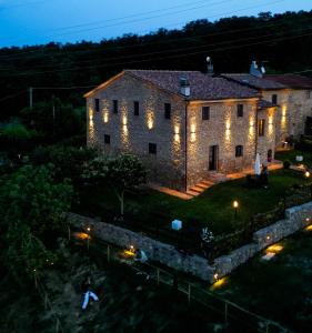 an old stone building with lights on it at night at Agriturismo Fonte Belvedere in Collesalvetti