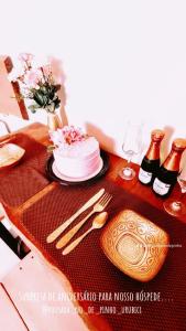 a table with a cake and some wine bottles at Pousada Nó de Pinho in Urubici