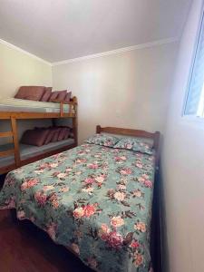 1 dormitorio con 1 cama con colcha de flores en Recanto Margarida, en Socorro
