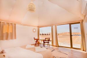 een slaapkamer met een bed, een bureau en een tafel bij Sahara Royal Resort in Merzouga