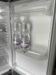 trzy butelki wody w otwartej lodówce w obiekcie Apartman III u centru Kutine w mieście Kutina