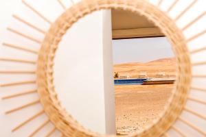 a wicker mirror with a view of the desert at Sahara Royal Resort in Merzouga